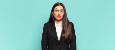 Genç, güzel bir kadın tatlı, eğlenceli, mutlu, sevimli bir yüz ifadesiyle dudaklarını birbirine bastırıyor ve öpüşüyor. iş kavramı