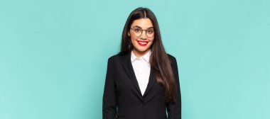 Genç, güzel bir kadın neşeli ve tesadüfen gülümsüyor. Olumlu, mutlu, kendinden emin ve rahat bir ifadeyle. iş kavramı