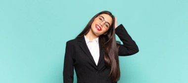 Genç, güzel bir kadın neşeli ve sıradan bir şekilde gülümsüyor, olumlu, mutlu ve kendinden emin bir bakışla göğüs göğüse tutuşuyor. iş kavramı