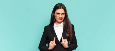 Genç ve güzel bir kadın şaşkın ve şaşkın bir bakışla kendini işaret ediyor. Seçildiğine şaşırmış ve şaşırmış. iş kavramı