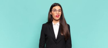 Genç, güzel bir kadın şoke olmuş, mutlu, şaşkın ve şaşırmış hissediyor, ağzı açık bir şekilde yana bakıyor. iş kavramı