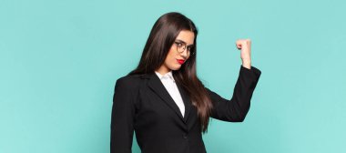 Genç, güzel bir kadın kendini mutlu, tatmin olmuş ve güçlü hissediyor, kaslı ve formda, spor salonundan sonra güçlü görünüyor. iş kavramı