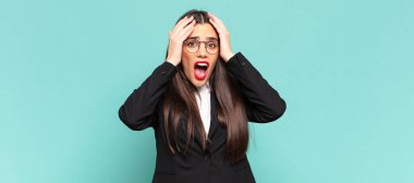 Genç, güzel bir kadın dehşete kapılmış ve şok olmuş hissediyor. Bir hata karşısında ellerini kaldırıyor ve panikliyor. iş kavramı