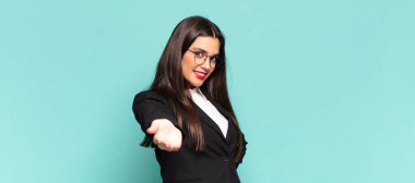 Genç, güzel bir kadın gülümsüyor, mutlu, kendinden emin ve arkadaş canlısı görünüyor, bir anlaşmaya varmak için el sıkışmayı teklif ediyor, işbirliği yapıyor. iş kavramı