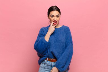 Şaşırmış, gergin, endişeli ya da korkmuş bakışları olan genç, güzel bir kadın.