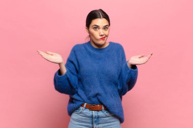 Genç, güzel bir kadın şaşkın ve kafası karışık, şüpheci, farklı seçenekleri tartıyor ya da komik bir ifadeyle seçiyor.