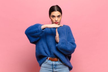 Genç ve güzel bir kadın ciddi, sert, kızgın ve hoşnutsuz görünüyor.