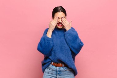 Genç ve güzel bir kadın gülümsüyor ve mutlu hissediyor, iki eliyle gözlerini kapatıyor ve inanılmaz bir sürpriz bekliyor.