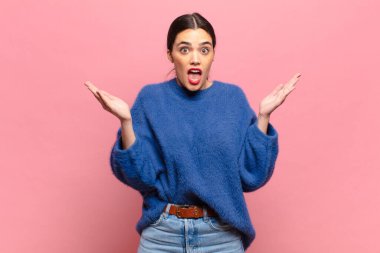 Genç, güzel bir kadın mutlu, heyecanlı, şaşırmış ya da şaşırmış hissediyor. İnanılmaz bir şeye gülümsüyor ve hayrete düşüyor.