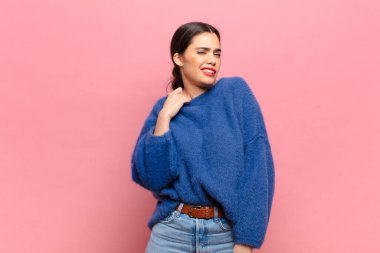 Genç, güzel bir kadın stresli, endişeli, yorgun ve hayal kırıklığına uğramış, gömleğini çekiştirmiş, sorunlu görünüyor.