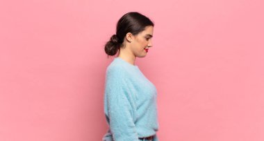 Profil görünümünde genç ve güzel bir kadın ilerideki boşluğu kopyalamaya çalışıyor, düşünüyor, hayal ediyor ya da hayal kuruyor.