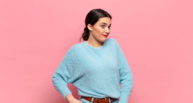 Genç, güzel bir kadın gururlu, kendinden emin, havalı, küstah ve kibirli görünüyor, gülümsüyor, başarılı hissediyor