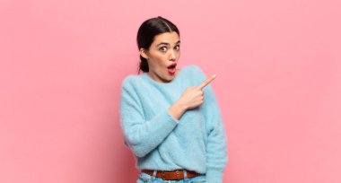 Genç ve güzel bir kadın heyecanlı ve şaşırmış görünüyor.