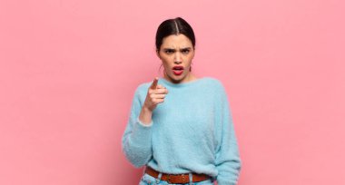 Genç ve güzel bir kadın kızgın agresif bir ifadeyle kameraya bakıyor. Öfkeli, çılgın bir patron gibi görünüyor.