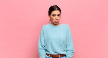 Genç ve güzel bir kadın üzgün ve mızmızlanıyor, mutsuz bir bakışla, negatif ve hayal kırıklığına uğramış bir tavırla ağlıyor.