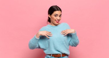 Genç, güzel bir kadın mutlu, şaşırmış, gururlu ve heyecanlı görünüyor.