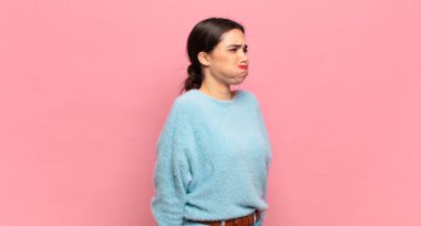 Şapşal, çılgın, şaşkın bir ifadeyle genç, güzel bir kadın. Yanakları şişmiş, içi doldurulmuş, şişman ve yemek dolu.