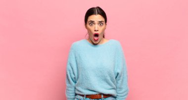 Genç ve güzel bir kadın korkmuş ve şok olmuş hissediyor, ağzı açık bir şekilde şaşkınlık içinde.