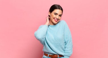 Genç, güzel bir kadın neşeli ve kendinden emin bir şekilde gülüyor. Sıradan, mutlu, dostane bir gülümsemeyle.