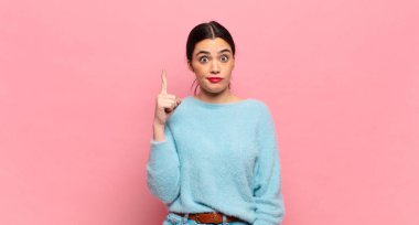 Genç ve güzel bir kadın, harika bir fikri fark ettikten sonra parmağını havaya kaldırıp 