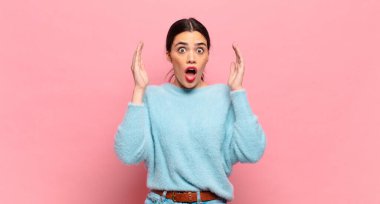 Genç ve güzel bir kadın ellerini havaya kaldırarak bağırıyor. Öfkeli, sinirli, stresli ve üzgün.