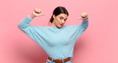 Genç, güzel bir kadın gururlu, kibirli ve kendinden emin, tatmin olmuş ve başarılı görünüyor, kendini işaret ediyor.