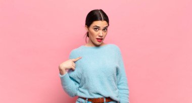 Kafası karışmış, kafası karışmış ve kendine güveni olmayan genç bir kadın kendini göstererek kim olduğunu soruyor, ben mi??