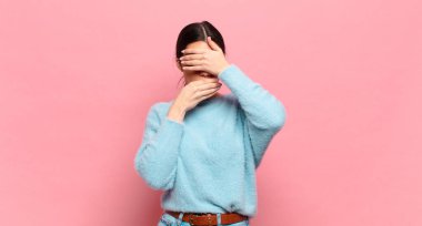 Genç ve güzel bir kadın iki eliyle kameraya hayır diyerek yüzünü kapatıyor! Resimler reddediliyor ya da yasaklanıyor