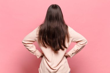 Genç, güzel bir kadın, kafası karışık ya da dolu ya da şüphe ve soru dolu, merak ediyor, elleri kalçasında, dikiz aynasından.