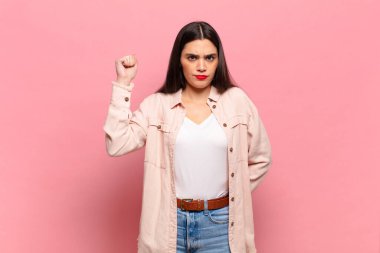 Genç ve güzel bir kadın ciddi, güçlü ve isyankar hissediyor, yumruğunu kaldırıyor, protesto ediyor ya da devrim için savaşıyor.