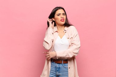 Genç ve güzel bir kadın stresli, hayal kırıklığına uğramış ve yorgun, endişeli ve sorunlu bir bakışla boynunu ovalıyor.