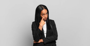 young black woman keeping an eye on you, not trusting, watching and staying alert and vigilant. business concept