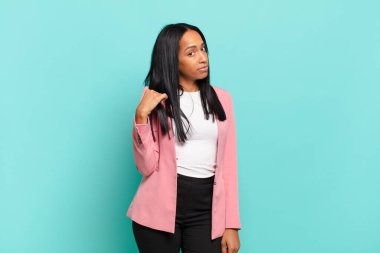 young black woman looking arrogant, successful, positive and proud, pointing to self. business concept