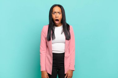 young black woman looking shocked, angry, annoyed or disappointed, open mouthed and furious. business concept
