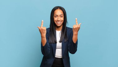 young black woman feeling provocative, aggressive and obscene, flipping the middle finger, with a rebellious attitude. business concept