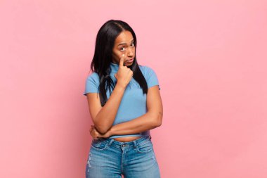 young black woman keeping an eye on you, not trusting, watching and staying alert and vigilant