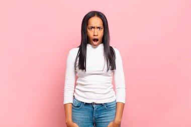 Genç siyahi kadın şok olmuş, kızgın, sinirli ya da hayal kırıklığına uğramış, ağzı açık ve öfkeli görünüyor.