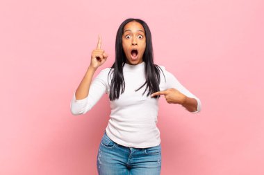 Genç siyah kadın gururlu ve şaşırmış hissediyor, kendine güvenen, başarılı bir numara gibi hisseden.