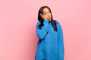 Genç siyahi kadın ağzı açık bir şekilde yüz yüze inanmayarak şok olmuş ve hayrete düşmüş hissediyor.