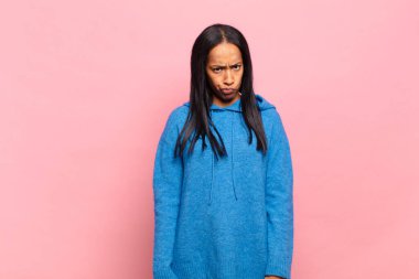 Genç siyahi kadın kendini şaşkın ve şüpheli hissediyor, merak ediyor ya da karar vermeye çalışıyor.