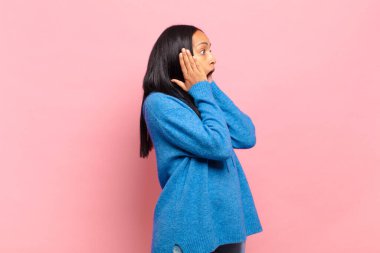 Genç siyahi kadın mutlu, heyecanlı ve şaşırmış hissediyordu. İki eli de havada bir tarafa bakıyordu.