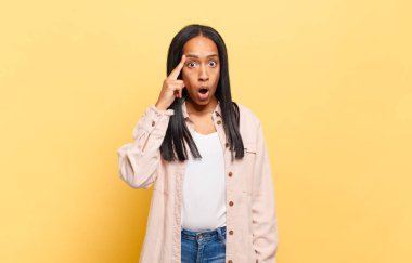 Genç siyahi kadın şaşırmış, ağzı açık, şok olmuş, yeni bir düşünce, fikir ya da konsept keşfediyor.