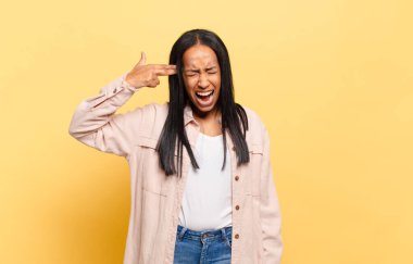 Genç siyahi kadın mutsuz ve stresli görünüyor, intihar jesti elle silah işareti yapıyor, kafasını işaret ediyor.