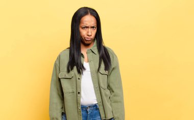 Genç siyahi kadın kendini şaşkın ve şüpheli hissediyor, merak ediyor ya da karar vermeye çalışıyor.