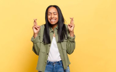 Genç siyahi kadın gergin ve umutlu, şans diliyor ve dua ediyor.