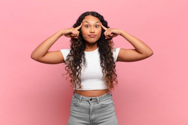 Genç İspanyol kadın kafası karışmış ya da şüpheye düşmüş, bir fikre odaklanmış, çok düşünüyor, kenarda boşluğu kopyalamak istiyor.