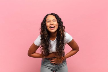 Genç İspanyol kadın komik bir şakaya yüksek sesle gülüyor, mutlu ve neşeli hissediyor, eğleniyor.