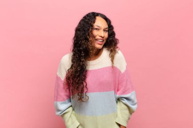 Genç İspanyol bir kadın, büyük, dost canlısı, kaygısız bir gülümsemesi var, pozitif, rahat ve mutlu görünüyor, ürpertici.