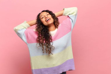 Genç İspanyol kadın gülümsüyor ve rahatlıyor, tatmin oluyor ve kaygısızca gülüyor.