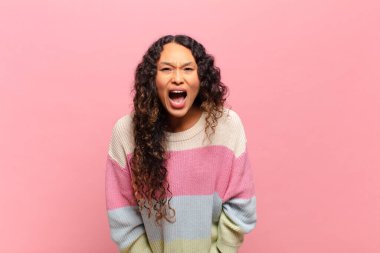 Genç İspanyol kadın agresif bir şekilde bağırıyor, çok kızgın, hayal kırıklığına uğramış, öfkeli ya da sinirli görünüyor, hayır diyor.
